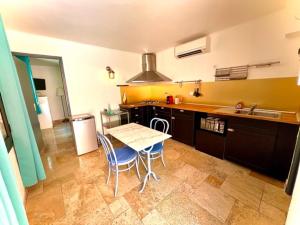 a kitchen with a table and chairs and a sink at Annexe Bastide du Paradou in Moustiers-Sainte-Marie