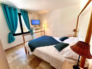 a bedroom with a bed with a blue blanket at Annexe Bastide du Paradou in Moustiers-Sainte-Marie