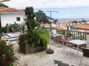 patio ze stołami i krzesłami na balkonie w obiekcie Pensao Residencial Vila Teresinha w Funchal
