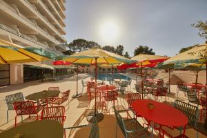 a group of tables and chairs with umbrellas at Dreams Calvia Mallorca in Magaluf