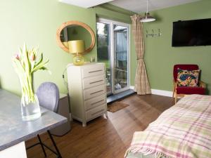 a bedroom with a bed and a table with a mirror at Stunning Studio in Corbridge, Northumberland in Corbridge