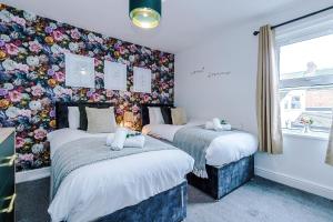Duas camas num quarto com papel de parede floral em Stylish 2-Bed City-Centre Home in Chester by 53 Degrees Property - Ideal for Couples & Groups - Sleeps 6 em Chester