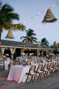 a long table with white tables and chairs at COMO Parrot Cay in Sandy Point