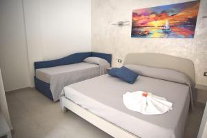 a room with two beds and a painting on the wall at Angelo Bianco Appartment in Porto Cesareo