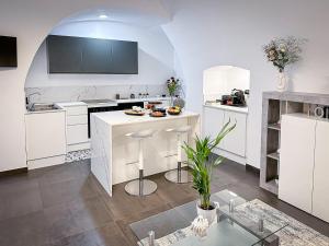 a kitchen with white cabinets and a white counter top at Marbel Suite in Adelfia