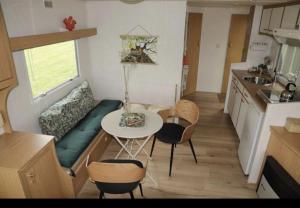 a small kitchen with a table and chairs in a tiny house at Tiny House in de wei in Holten