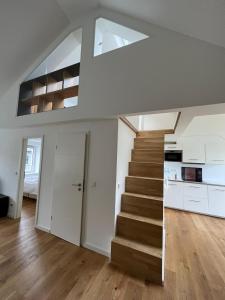 uma escadaria numa sala de estar com paredes brancas e pisos em madeira em Core Luxembourg City em Luxemburgo