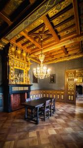 comedor con mesa, sillas y lámpara de araña en Castle ten Berghe Château, en Brujas