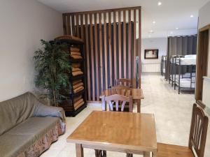 - un salon avec un canapé et une table dans l'établissement Albergue Restaurante Casa Herminia, à El Campiello