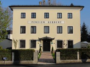 un edificio con un letrero que lee terapeuta autorizado en Hotel Pension Herbert, en Salzburgo