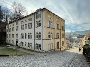 a large white building with people walking in front of it at Bergblick Apartment Sächsische Schweiz in Sebnitz