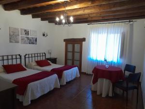 a bedroom with two beds and a table and a window at El Molino in Nieva
