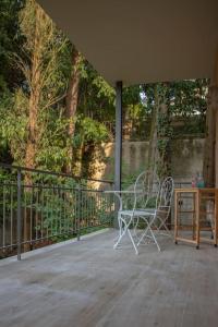 a patio with two chairs and a table and a fence at House Of Music in Gardone Riviera