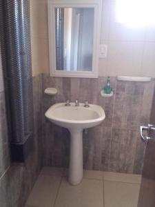 a bathroom with a white sink and a mirror at Ayres Pampeanos in Santa Rosa +14 photos