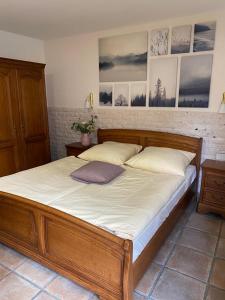 Hotel Zur Linde في سارلويس: سرير خشبي في غرفة نوم مع صور على الحائط