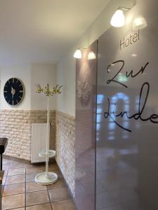 una tienda con un reloj en la pared y una puerta de cristal en Hotel Zur Linde en Saarlouis