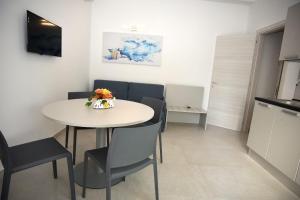 a dining room with a white table and chairs at Angelo Bianco Appartment in Porto Cesareo