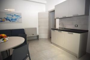 a kitchen with a table and a sink and a counter at Angelo Bianco Appartment in Porto Cesareo