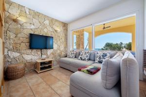 sala de estar con sofá y TV en The beauty of Cala Tamarit, en Tarragona