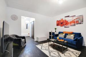 - un salon avec un canapé bleu et une table dans l'établissement Cosy appartement aux Portes de Paris, à Aubervilliers