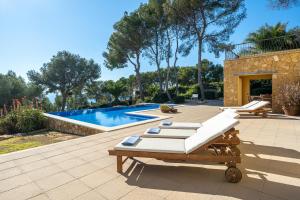 un patio con tumbonas y una piscina en The beauty of Cala Tamarit, en Tarragona