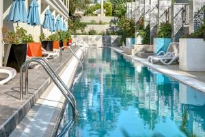 a swimming pool at a hotel with chairs and umbrellas at Seaden Valentine Resort & Spa Adults Only in Side