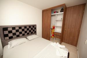 a bedroom with a bed with a checkered headboard at blue apartments in Cali