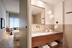 bagno con lavandino e specchio di The Social Athens Hotel, a member of Radisson Individuals ad Atene