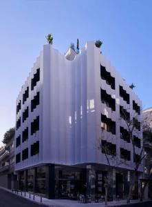 un gran edificio blanco en una calle de la ciudad en The Social Athens Hotel, a member of Radisson Individuals, en Atenas