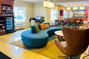 een woonkamer met een blauwe bank en een stoel bij Comfort Inn & Suites Olathe - Kansas City in Olathe