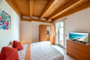 a bedroom with a bed and a flat screen tv at Casa Vacanza sotto torre in Calasetta