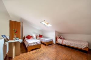 a room with two beds and a table and a desk at Casa Vacanza sotto torre in Calasetta