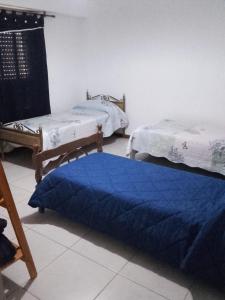 Pokój z 2 łóżkami i niebieskim kocem na podłodze w obiekcie Ayres Pampeanos w mieście Santa Rosa