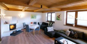 sala de estar con sofá, mesa y chimenea en HauserA Appartement, en Sankt Jakob in Haus