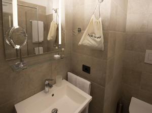 W łazience znajduje się biała umywalka i biała torba. w obiekcie Domus Altana w mieście Napoli