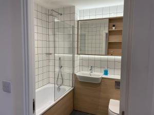 a bathroom with a tub and a sink and a shower at stylish modern one bed Apartment in Birmingham