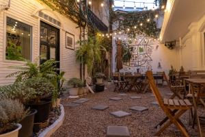 a patio with tables and chairs and potted plants at Baansuansao in Bang Rak