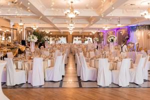 - une salle de banquet de mariage avec des tables et des chaises blanches dans l'établissement Oławian Hotel, à Oława
