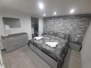 a bedroom with a large bed and a brick wall at House Under Arch in Palermo