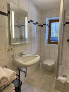 a white bathroom with a sink and a toilet at Haus Brandhofer in Häselgehr