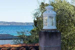 a light on a brick post with the ocean in the background at Casa Perdas - Gate to the Sea by Homey Experience in Olbia