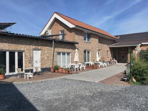 een bakstenen gebouw met tafels en stoelen op een patio bij Vakantiewoning Henisdael in Heers