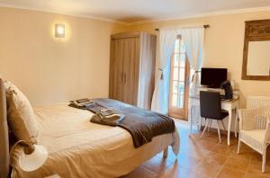 a bedroom with a bed with a desk and a window at Le Domaine de Camberoux La Grande Longère in Bressac