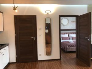 - une chambre avec un lit et un grand miroir dans l'établissement Holiday Apartments Browar Lubicz Krakow Stare Miasto, à Cracovie