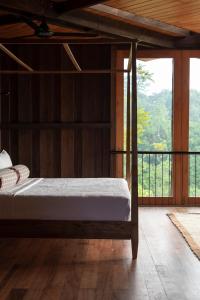 a bedroom with a bed and a balcony at Trebartha East The Round House in Ahangama