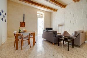 un soggiorno con un divano e un tavolo di Comfy 2 BR Flat in the Heart of Valletta a La Valletta