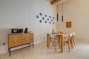 una sala da pranzo con tavolo, sedie e forno a microonde di Comfy 2 BR Flat in the Heart of Valletta a La Valletta