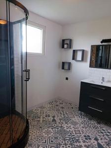 uma casa de banho com um chuveiro e um lavatório. em gite des Korrigans 