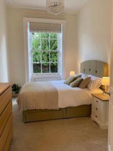 a bedroom with a large bed and a window at Regency Apartment in Leamington Spa