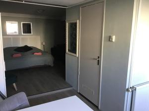 a bedroom with a bed and a door leading into a room at Life@Sea in Zandvoort